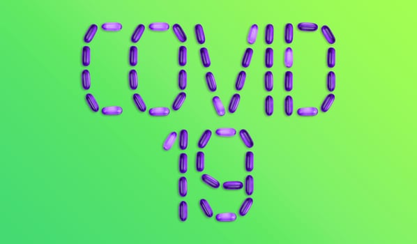 Covid 19 word made up of medicine pills on green background photo