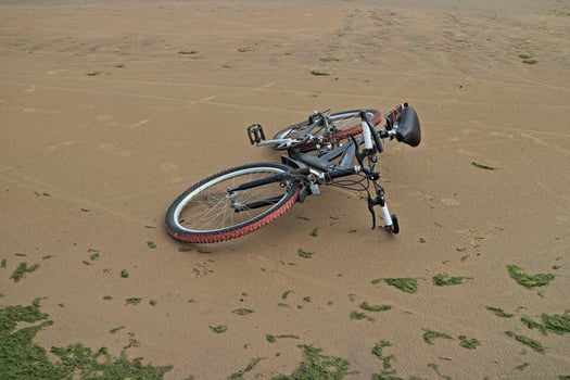Mountain bike lies on the sand on an empty beach photo