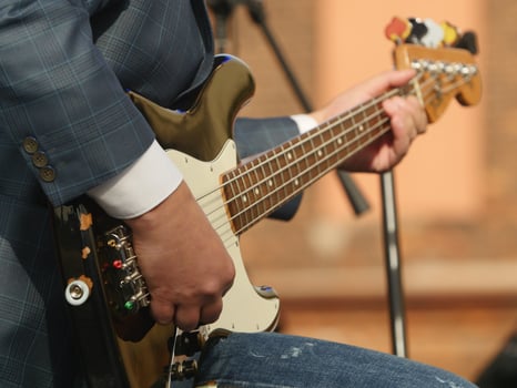 Musician hand playing bass guitar photo