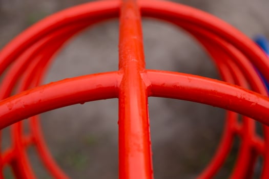 Red pipes in the playground close-up in raindrops photo