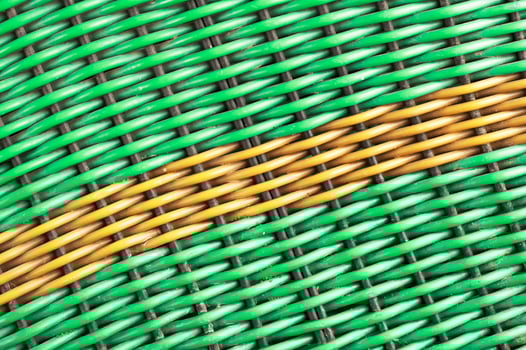 Green plastic woven background with a yellow diagonal line photo