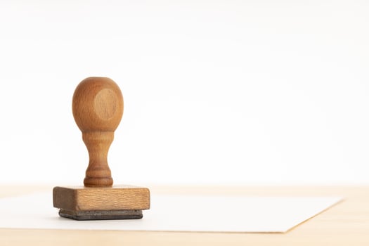 Vintage rubber stamp and blank paper on wooden table photo