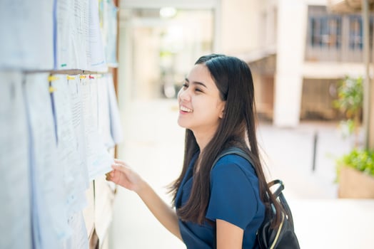A female university student is exciting with the exam report photo
