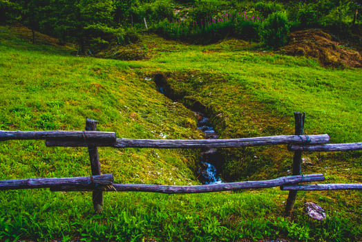 Meadow stream and wooden fence photo