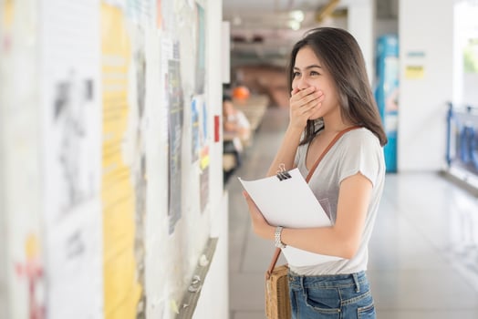 A female university student is exciting with the exam report photo