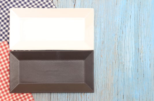 Black and white plate on tablecloth on wood table background photo
