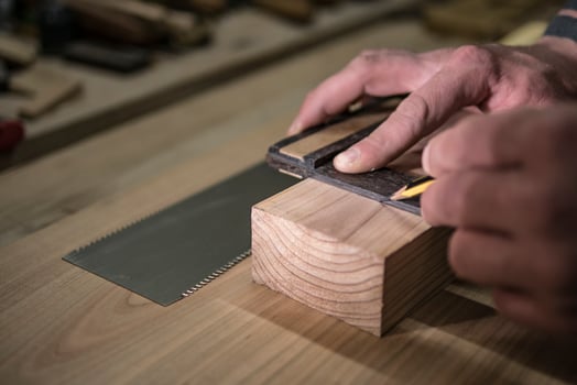 a joiner with a pencil and a square marks the workpiece photo