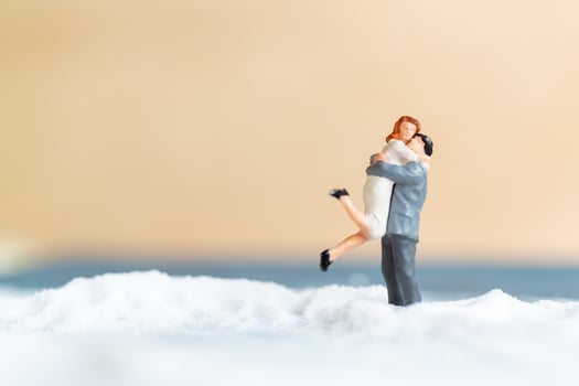 Miniature people, happy wedding couple on a white beach, wedding concept photo