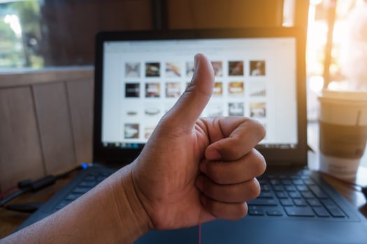 Human hand giving thumbs up in the blurred background photo