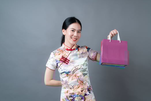 Asian woman wear Chinese traditional dress with hand holding shopping bag photo
