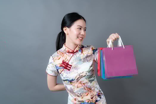 Asian woman wear Chinese traditional dress with hand holding shopping bag photo