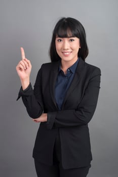Smiling business woman in blazer on grey background photo