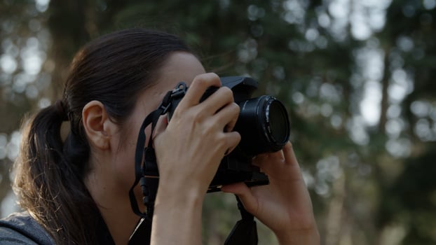 Portrait of woman taking photo with camera close up