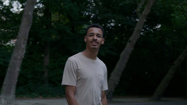 Portrait of young man walking in park looking at camera photo