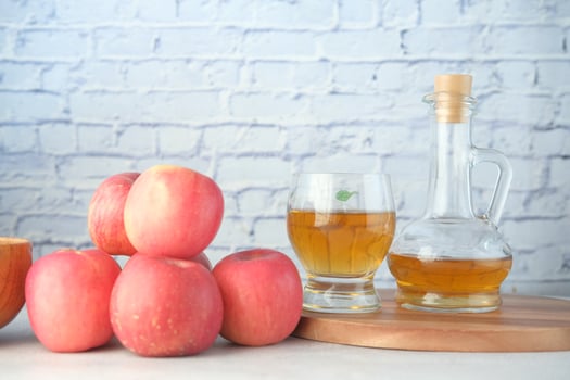 Apple vinegar in glass bottle with fresh green apple on table photo
