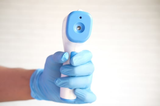 Hand holding infrared thermometer to measuring temperature. photo