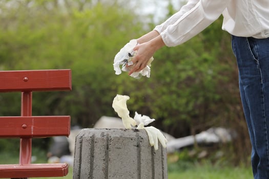 Woman throws plastic garbage in the trash photo
