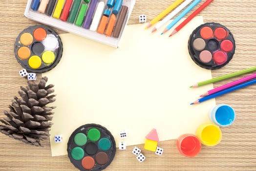Conceptual flatlay with drawing tools and a pine cone photo
