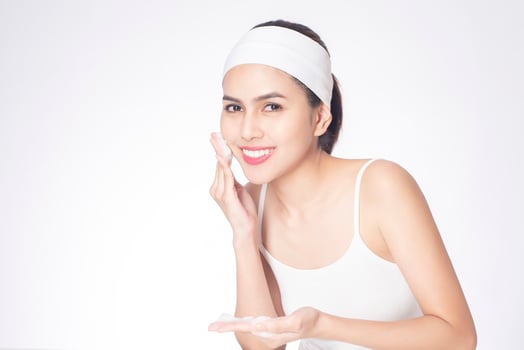 Beautiful woman is washing her face on white background photo