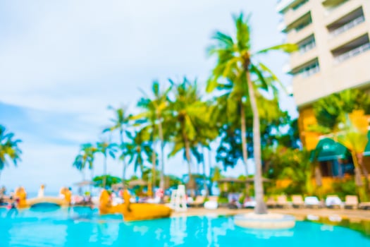 Abstract blur coconut palm tree around swimming pool photo