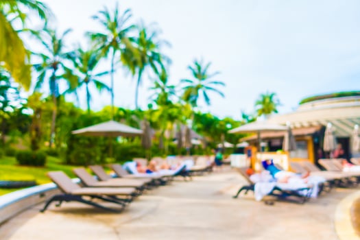 Abstract blur coconut palm tree around swimming pool photo