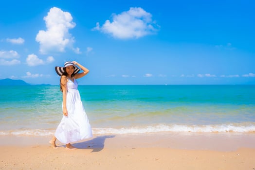 Portrait beautiful young asian woman happy smile leisure on the beach sea and ocean photo
