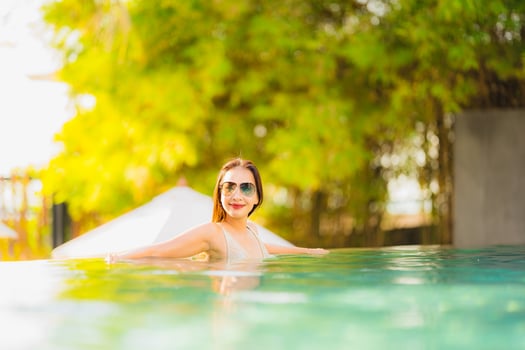 Portrait young beautiful asian woman happy smile and relax in swimming pool around hotel resort photo