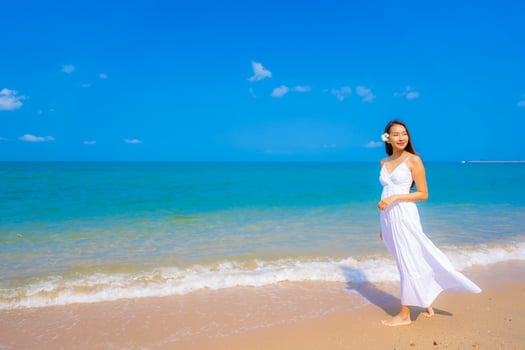 Portrait beautiful young asian woman happy smile leisure on the beach sea and ocean photo