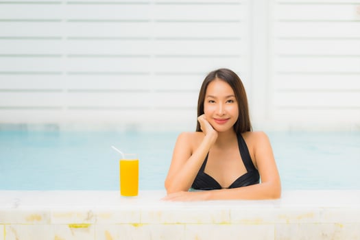 Portrait beautiful young asian woman happy smile relax around outdoor swimming pool photo