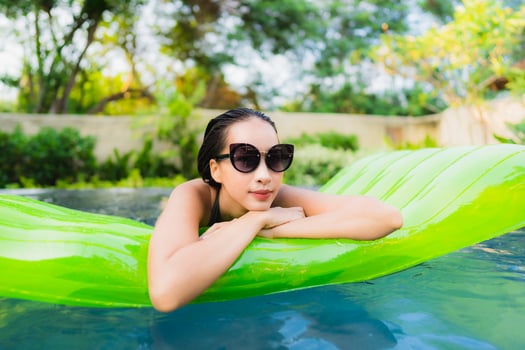 Portrait beautiful young asian woman smile happy relax and leisure in the swimming pool photo