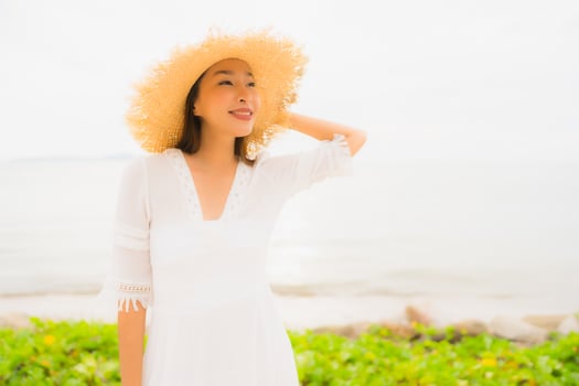 Portrait beautiful asian woman wear hat with smile happy leisure on the beach and sea in holiday vacation photo