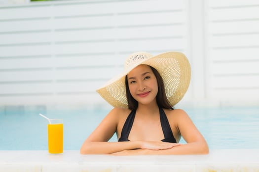 Portrait beautiful young asian woman happy smile relax around outdoor swimming pool photo