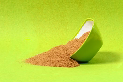 Coriander seeds and Powdered coriander in green container on green background photo