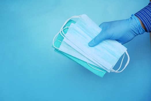 hand in medical glovers holding surgical face mask, photo