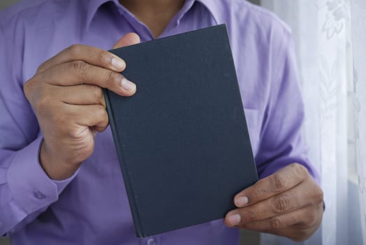 young man hand holding a book with empty space photo
