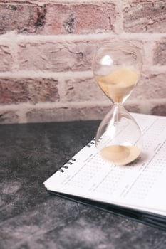 hourglass on a calendar, and flowing through the bulb of sandglass photo