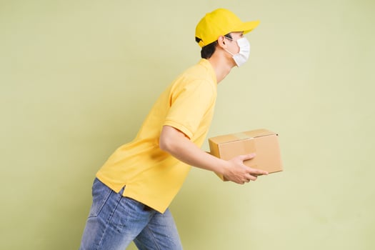 Asian delivery man is holding the carton with him and running to deliver the goods photo