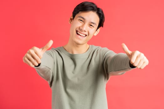 A photo of a handsome Asian man holding up 2 thumbs with a cheerful face