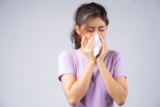 Young Asian woman is wiping her nose with a tissue photo