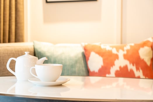 White tea cup with teapot on table photo