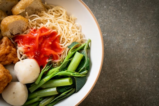 Egg noodles with fish balls and shrimp balls in pink sauce, Yen Ta Four or Yen Ta Fo - Asian food style photo