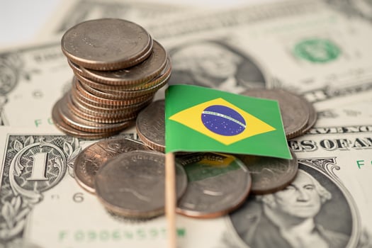 Stack of coins with Brazil flag on USA America dollar banknotes. photo