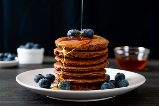 Chocolate pancake stack with blueberry and honey on a plate photo