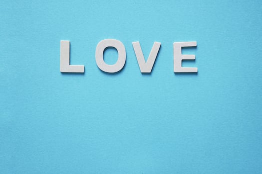 love word with wooden letters on the blue background for valentine's day photo