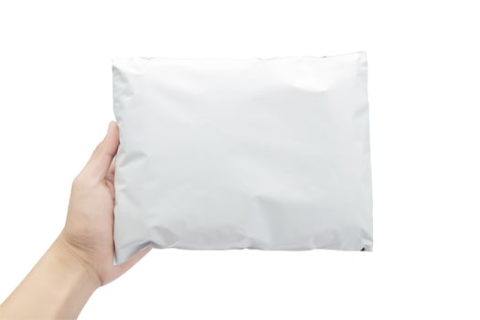 Hand holding white plastic package isolated on white background with clipping path photo