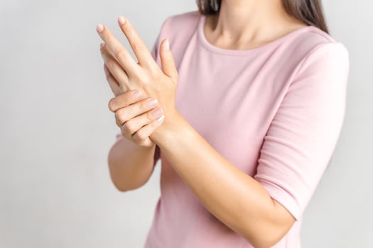 Closeup young woman holds her wrist on white background. hand injury, feeling pain. Health care and medical concept. photo