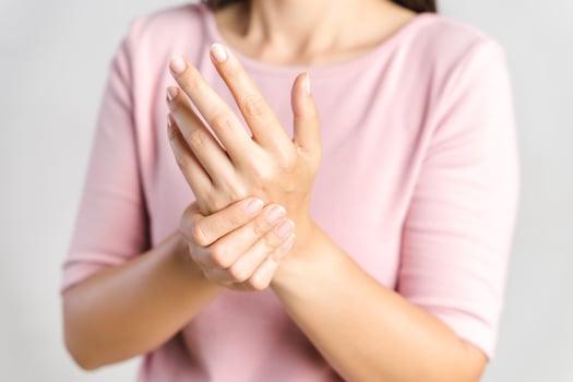 Closeup young woman holds her wrist on white background. hand injury, feeling pain. Health care and medical concept. photo