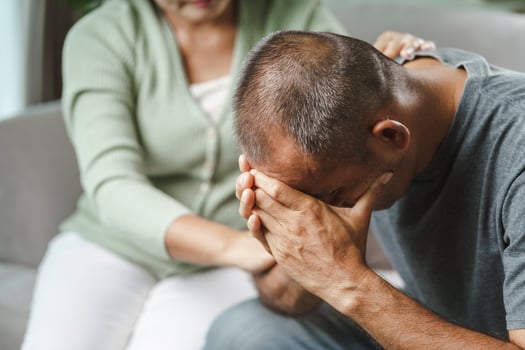 Female friend or family sitting and hold hands during cheer up to mental depress man, Psychologist provides mental aid to patient. PTSD Mental health concept photo