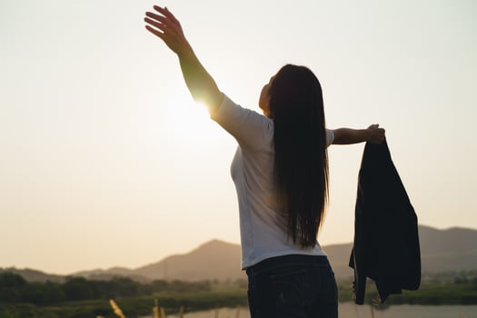 Happy business woman spreading arms and watching the mountain silhouette. Business success concept, freedom emotions photo