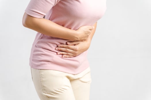 Young beautiful woman having painful stomachache on white background.Chronic gastritis. Abdomen bloating concept. photo
